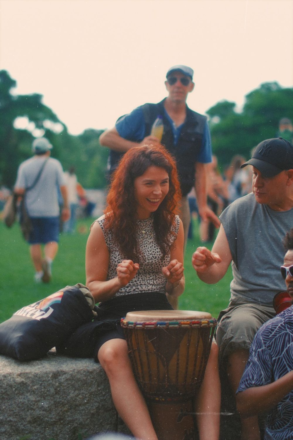People drumming together in a park
