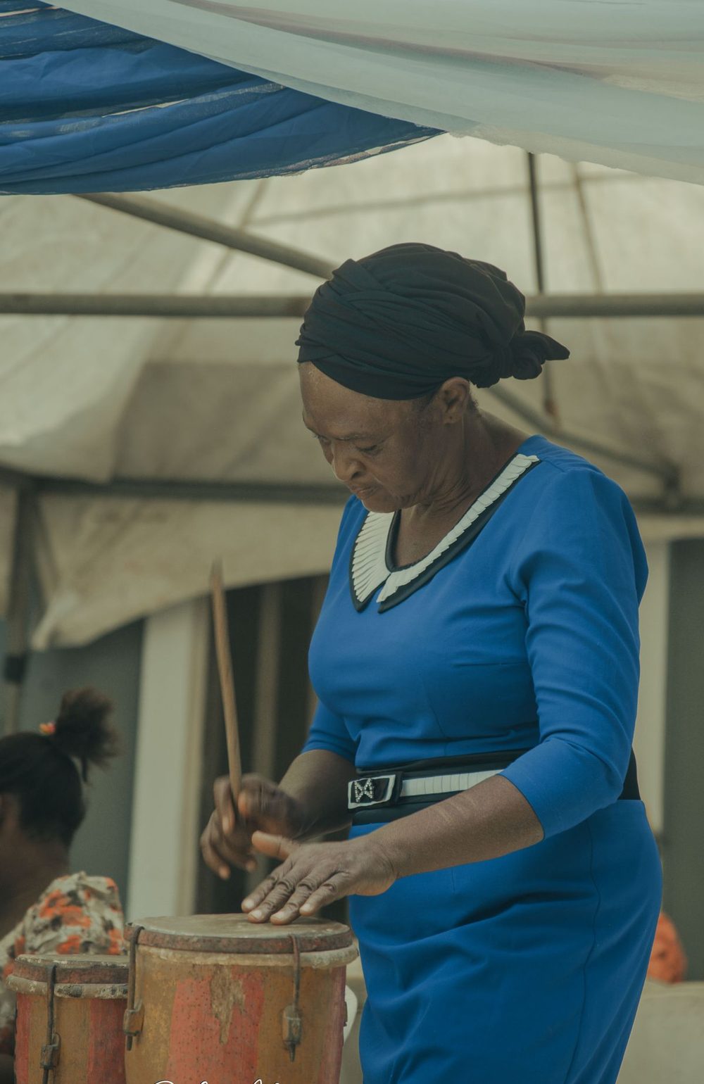 An elder playing a drum at a community gathering