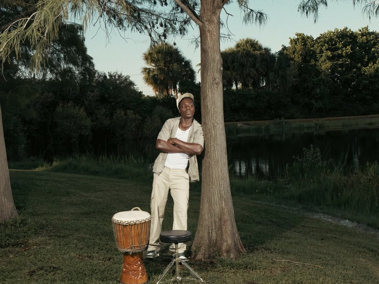 Marc Charlecine with his djembe under a cypress tree